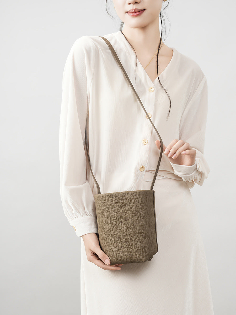Model wearing elephant gray mini bucket crossbody bag with cream outfit