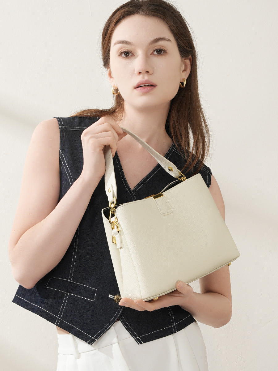 Model holding the off-white leather bucket bag