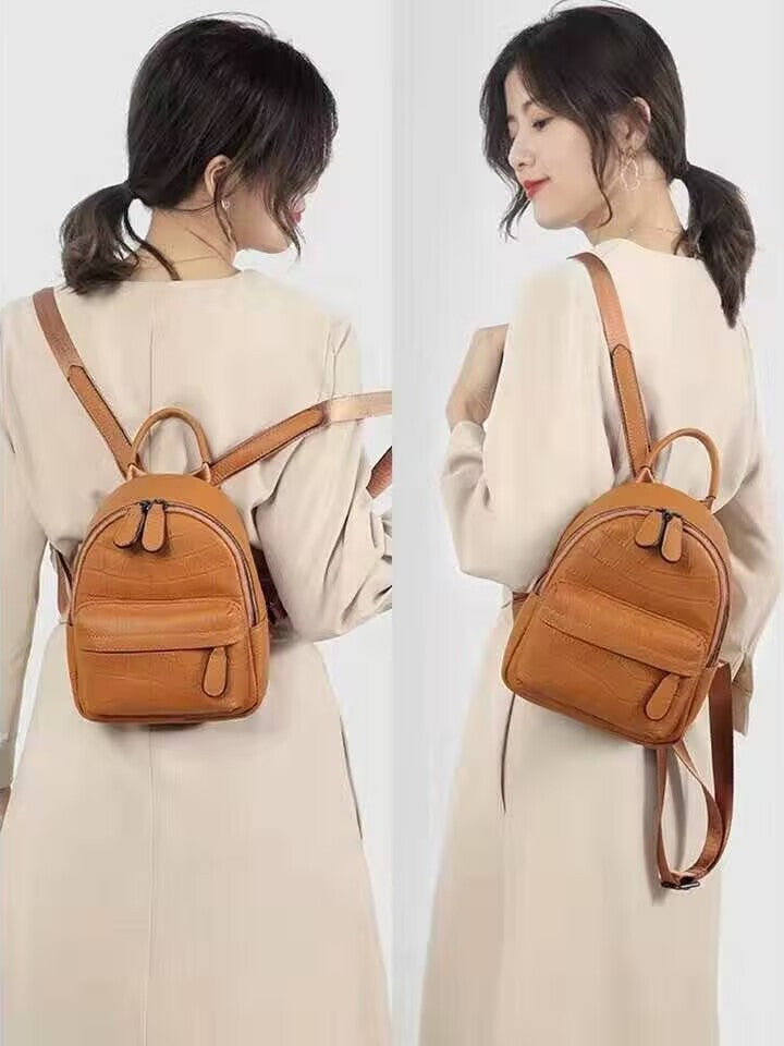Woman wearing a tan mini backpack with adjustable-looking shoulder straps