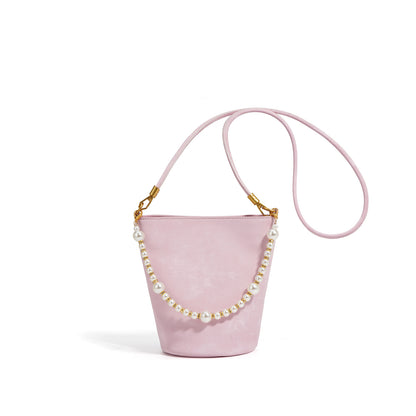 Blush pink split leather mini bucket bag with pearl chain on white background