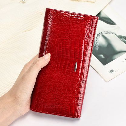 Red textured clutch wallet held upright in one hand