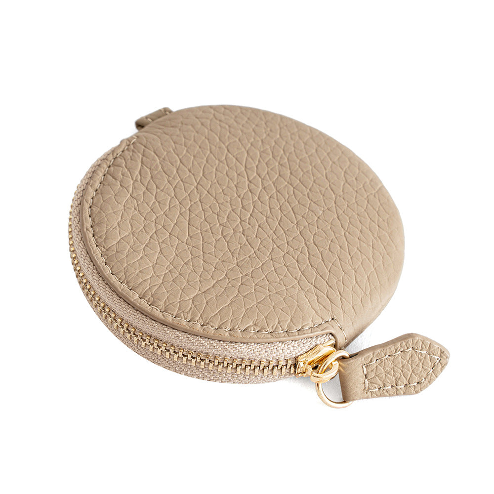 Ivory round leather coin purse side view showing zipper detail