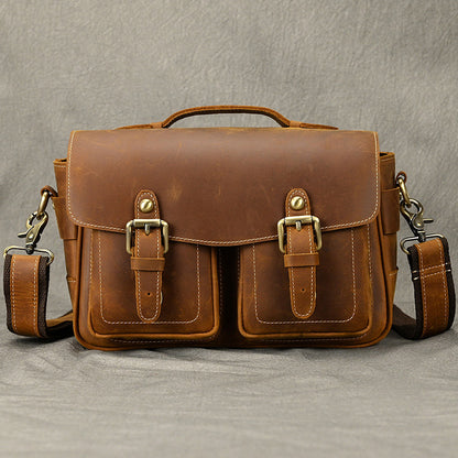 Brown leather camera bag shown with its shoulder strap