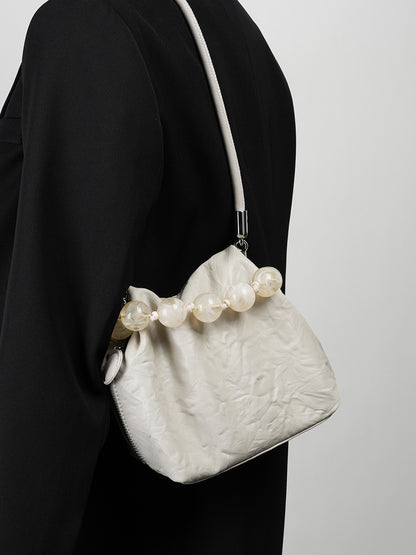 Off-white crinkle bag styled under the arm with a black blazer