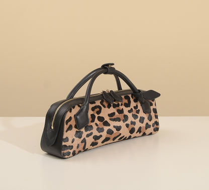 Structured leopard-print handbag with detachable strap laid alongside