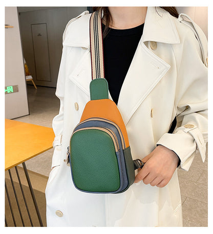 Close view of green leather sling bag and striped strap