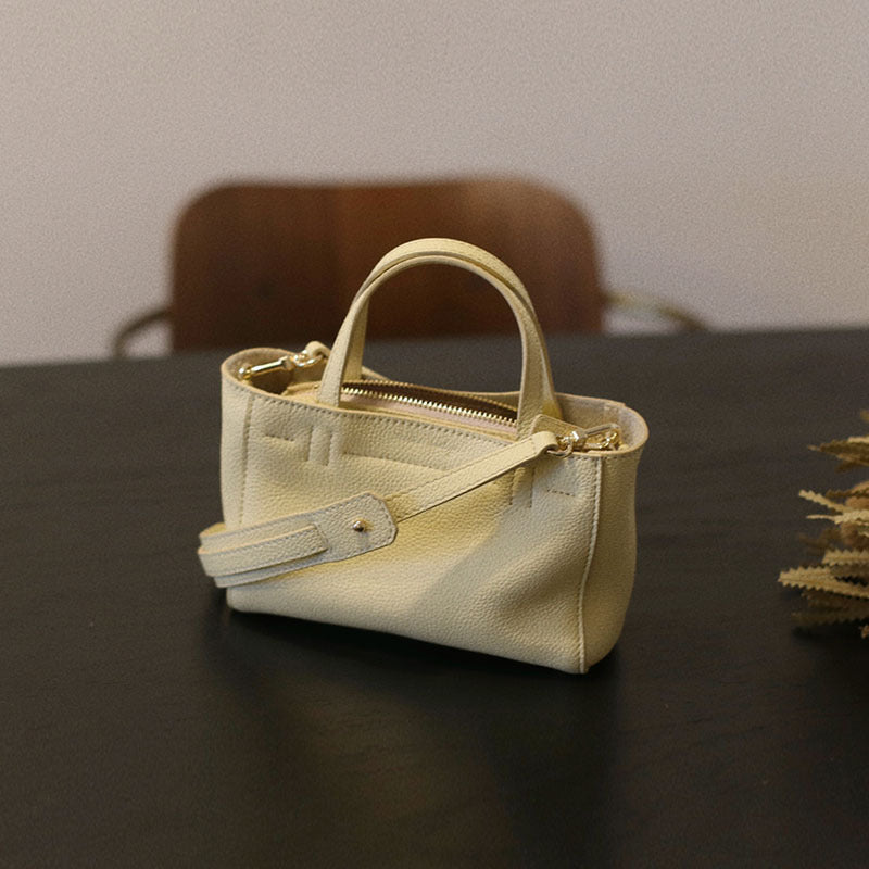 Close view of the cowhide tote's zip closure and handles