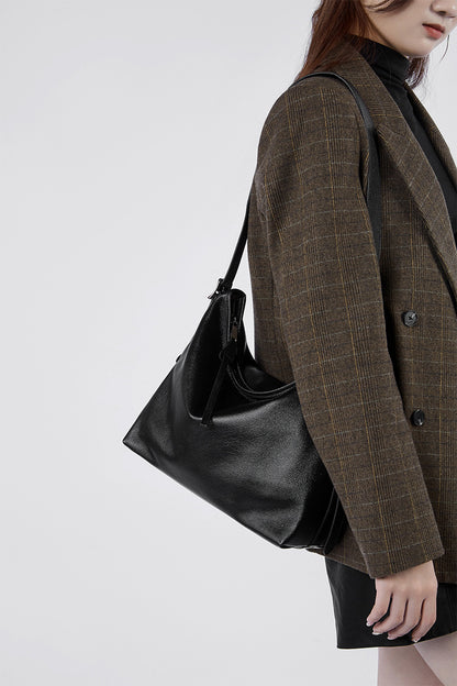 Black leather bag worn on the shoulder with a blazer