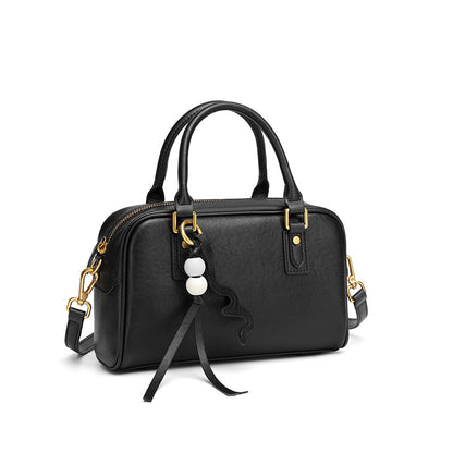 Black cowhide leather pillow bag with double top handles on a white background