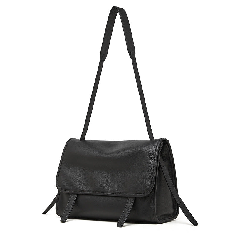 Black top-grain cowhide leather messenger crossbody bag with adjustable strap on white background