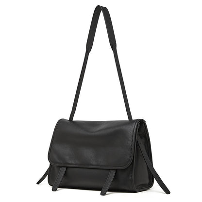 Black top-grain cowhide leather messenger crossbody bag with adjustable strap on white background