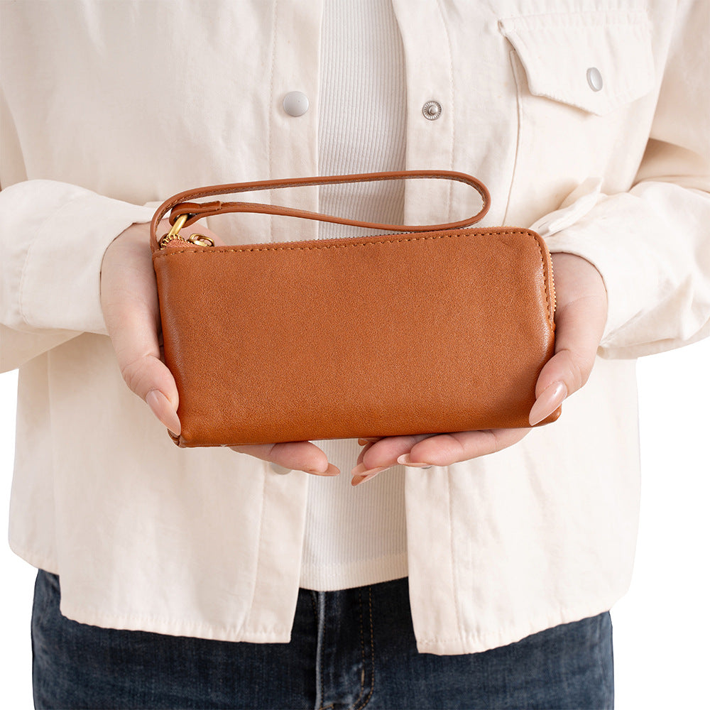 Coffee brown cowhide leather long wallet held in hands showing slim profile