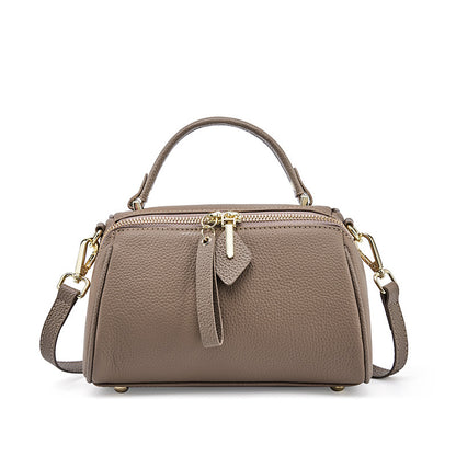 Gray top-grain cowhide mini Boston bag with pebbled texture and rolled top handle