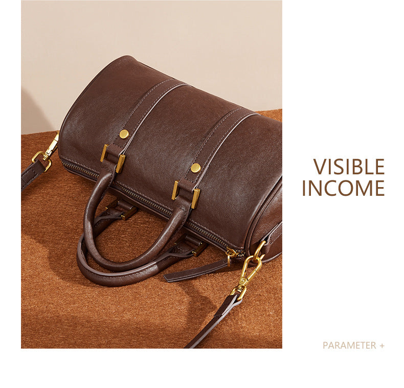 Close-up of dark brown Boston bag showing top zip and handle attachments