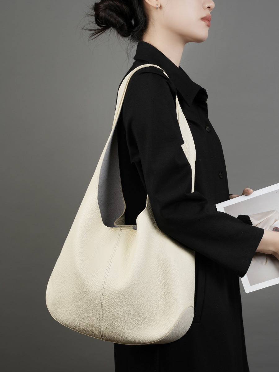 Off-white bucket tote worn over the shoulder with black outfit