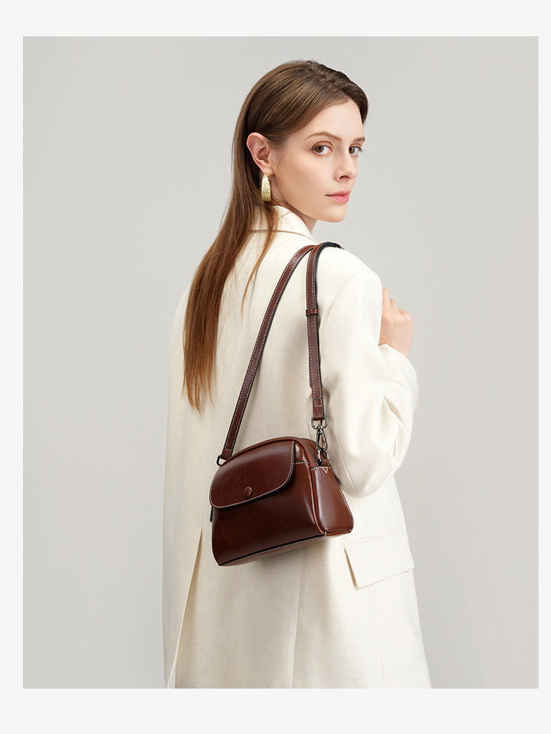 Back view of model wearing coffee leather crossbody bag