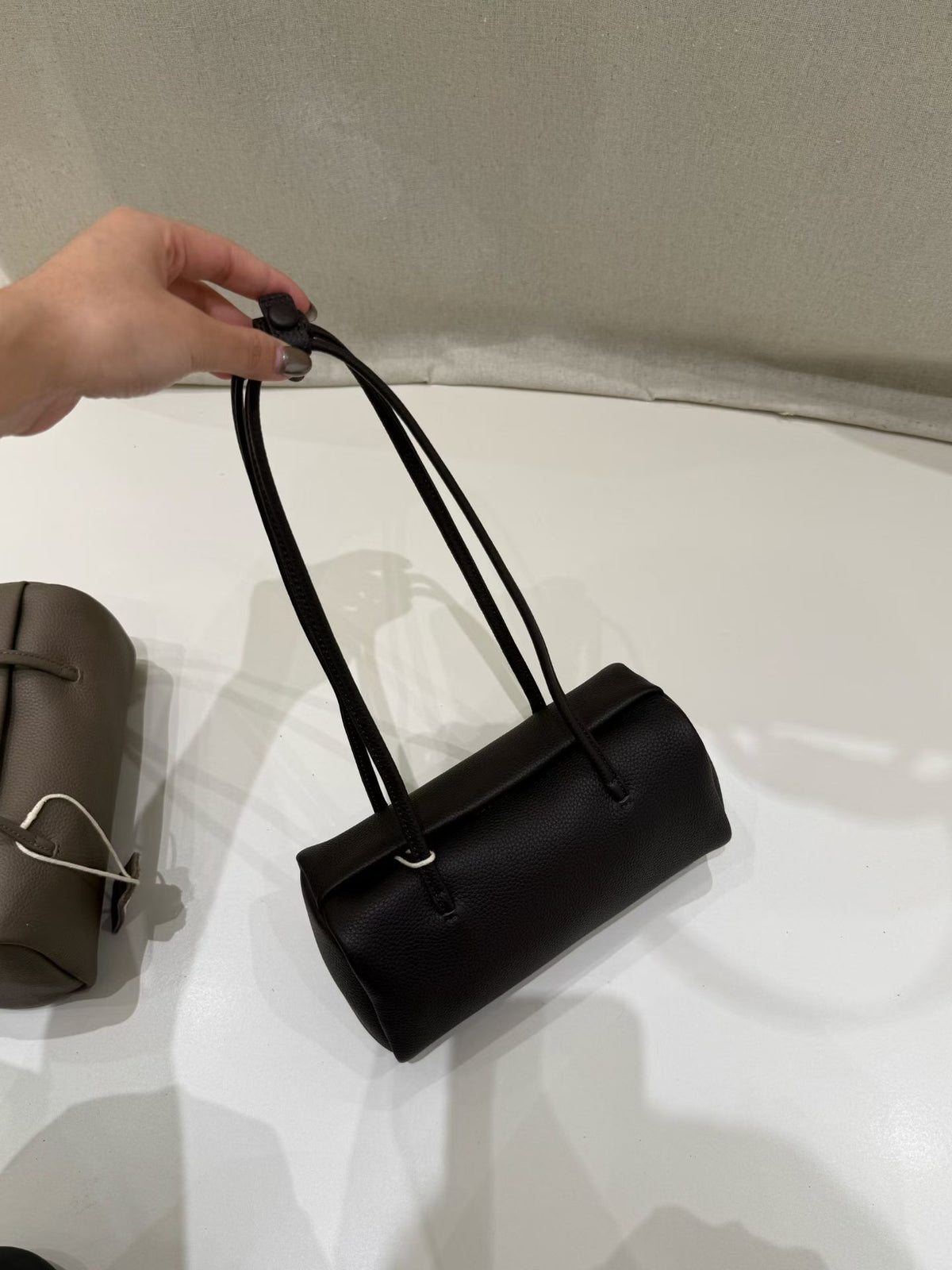Black shoulder bag held by its paired straps