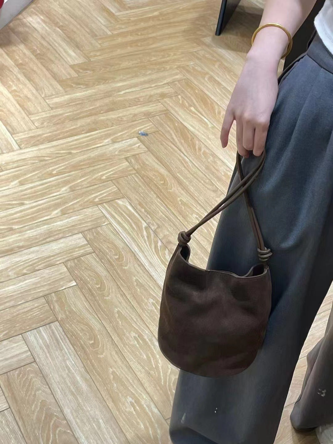 Brown bag held by its strap for a carry view