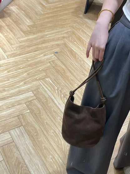 Brown bag held by its strap for a carry view