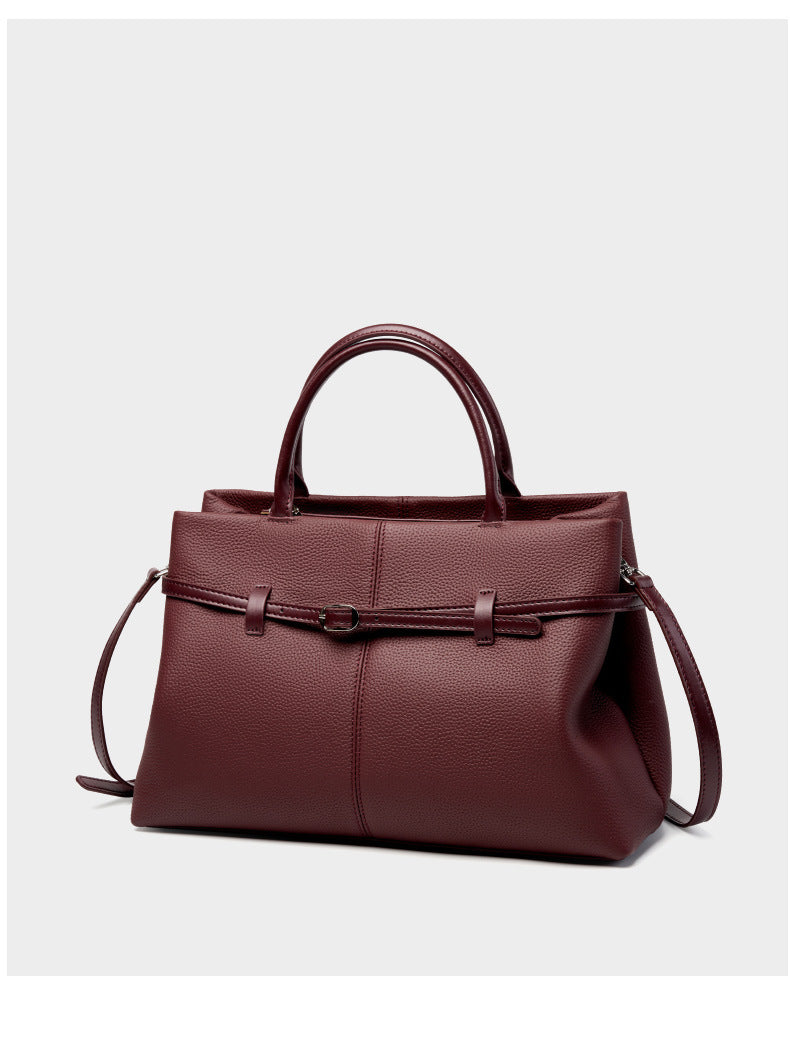 Wine red pebbled leather tote shown with adjustable strap detail