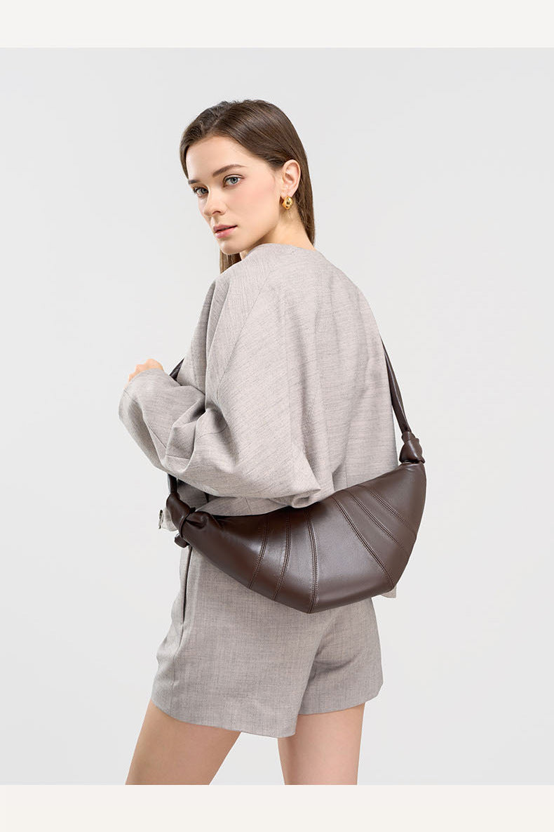 Back view of model wearing coffee crescent bag crossbody style