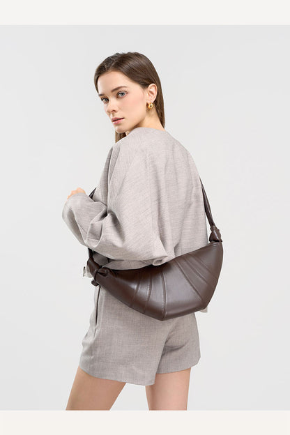 Back view of model wearing coffee crescent bag crossbody style
