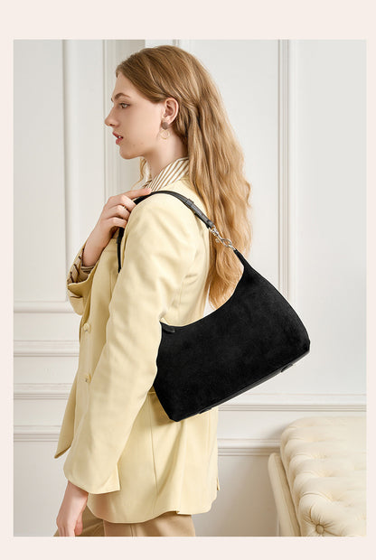 Black shoulder bag worn over the shoulder in profile