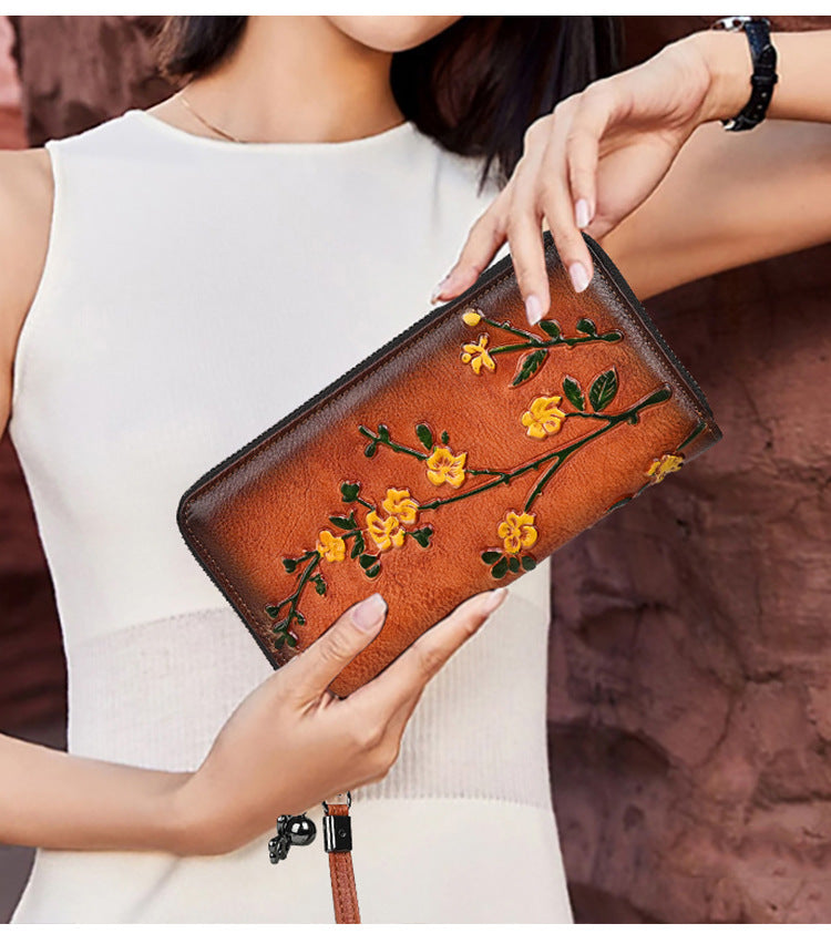Floral cowhide wallet held horizontally to show its long shape