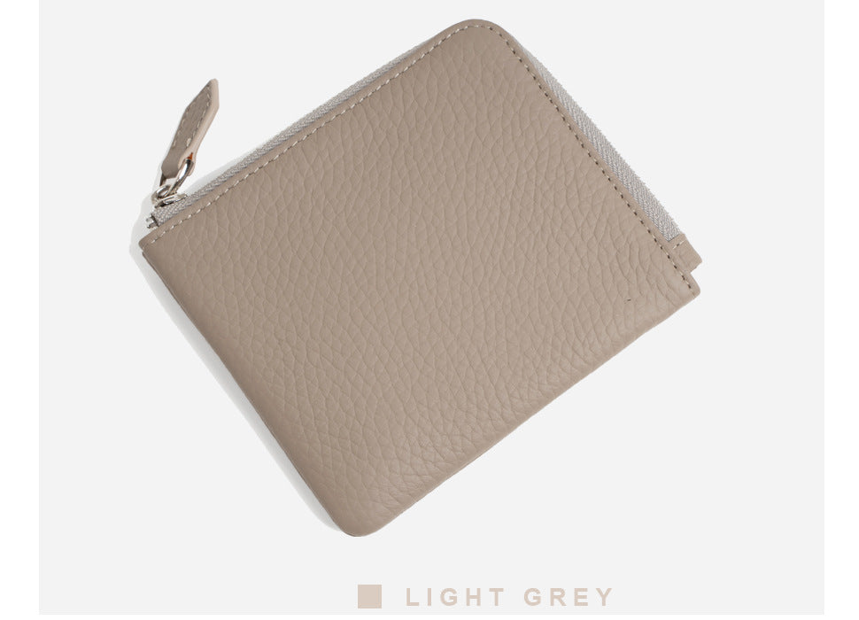 Light grey pebbled leather wallet angled showing zip pull detail