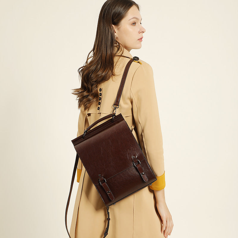 Brown leather backpack worn crossbody on model