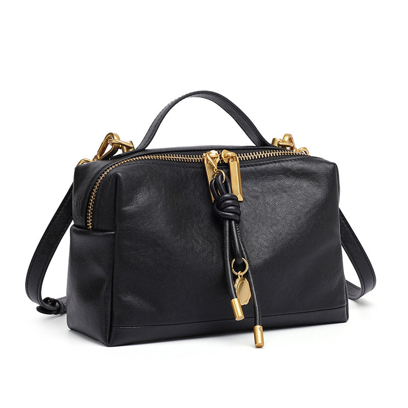 Black cowhide leather mini crossbody bag with gold-tone zipper on white background
