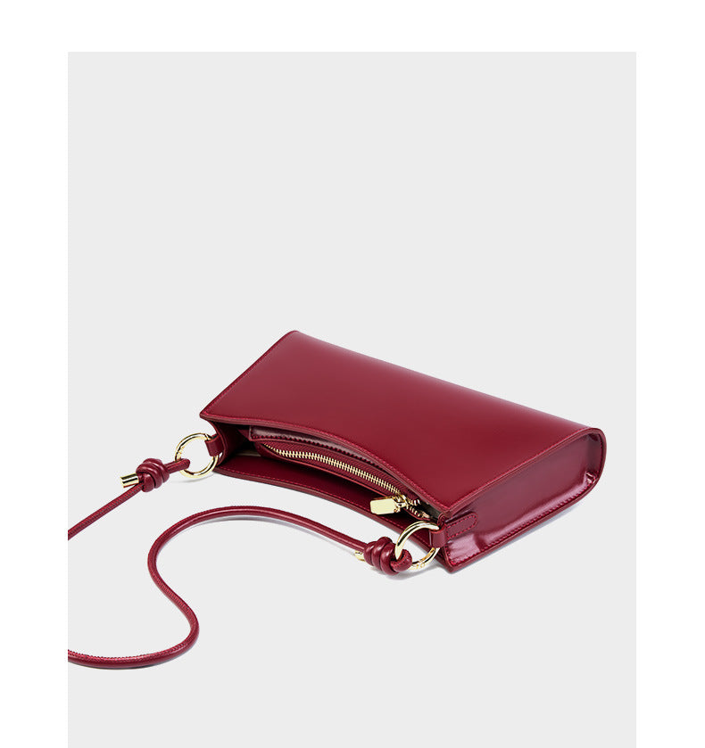 Wine red leather shoulder bag with strap extended showing top zip detail
