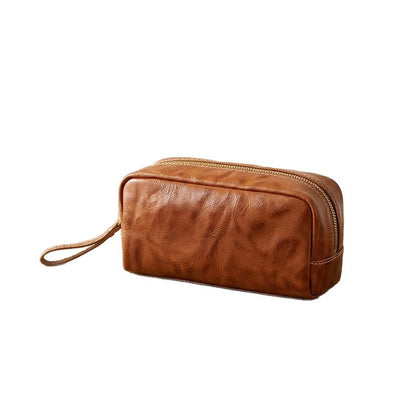 Leather wrist strap shown carrying the pouch by hand