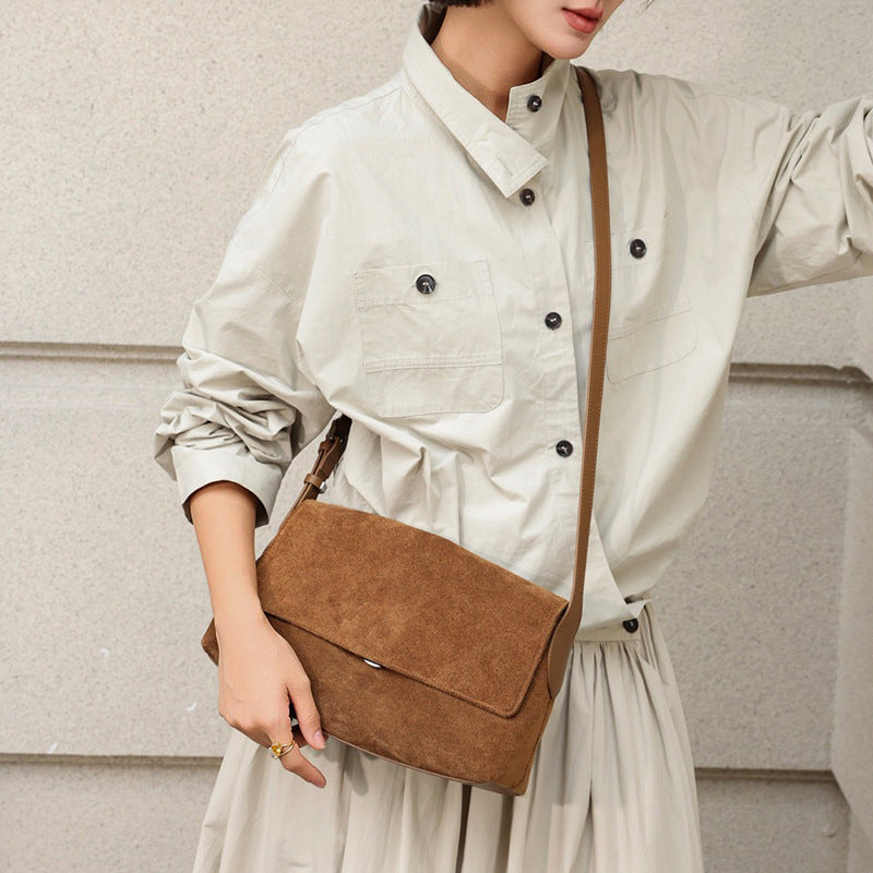 Caramel suede flap bag worn across the body