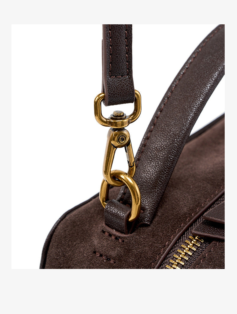Close-up of detachable strap connector and metal hardware on nubuck bag
