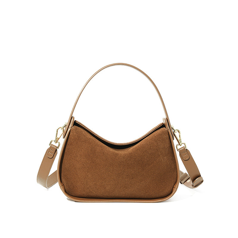 Brown suede cowhide shoulder bag with curved flap on a white background