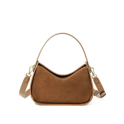Brown suede cowhide shoulder bag with curved flap on a white background
