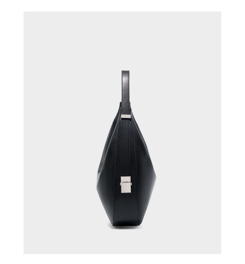 Side profile view of the black cowhide leather crescent hobo bag showing the slim depth and side strap detail