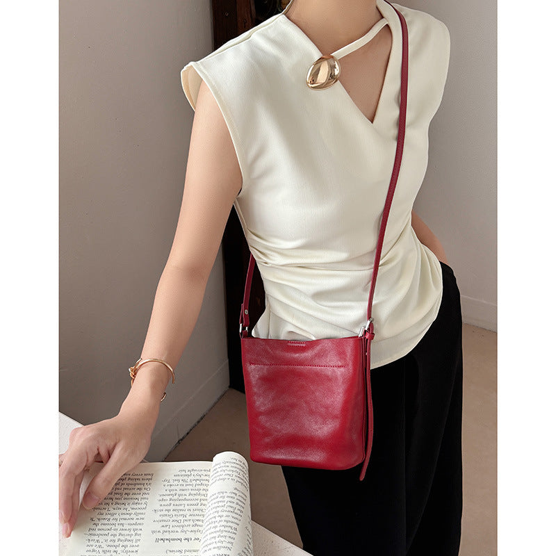 Burgundy bucket bag shown worn crossbody