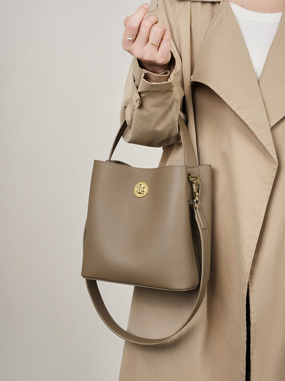 Khaki bucket bag paired with trench coat outfit