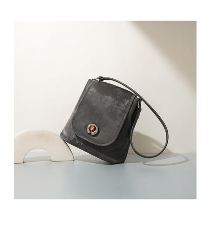Pewter gray split leather bucket bag angled side view on table