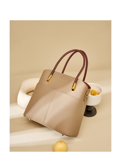 Gray bucket bag styled with a ceramic vessel and yellow plums