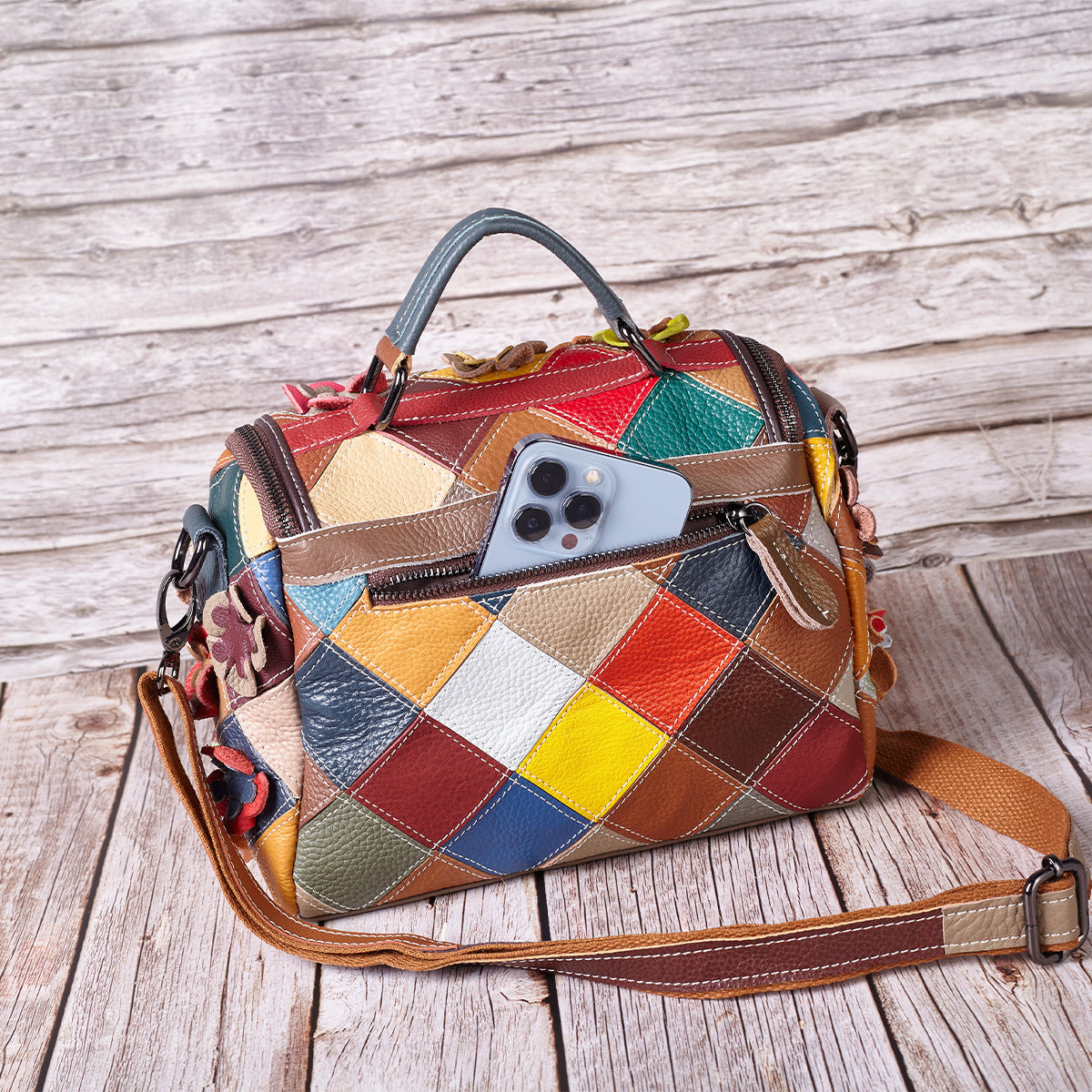 Angled view of the colorful patchwork bag with its strap laid out