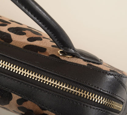 Macro view of the top handle, stitching, and zipper edge
