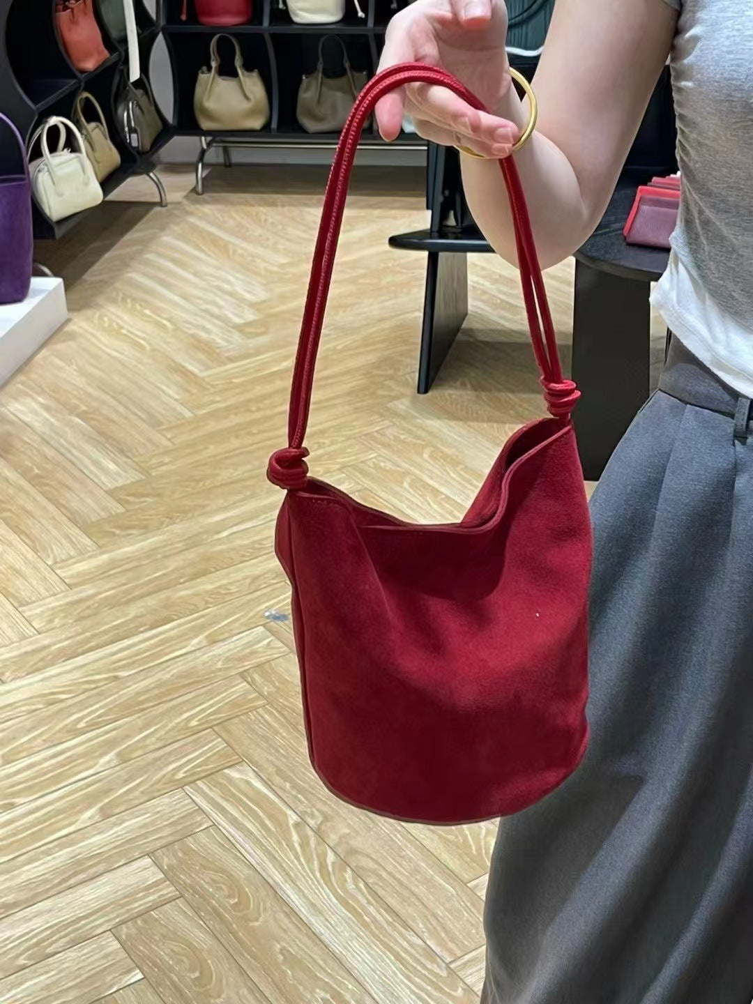 Red bucket bag shown from an angled side view