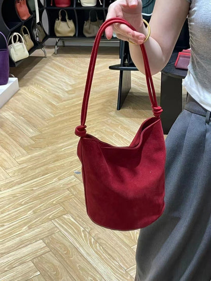 Red bucket bag shown from an angled side view