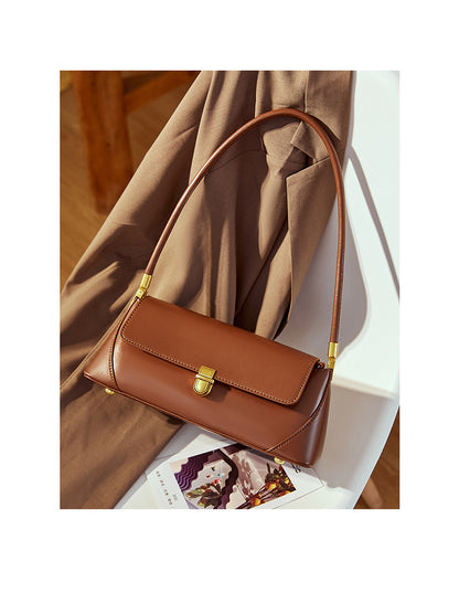 Coffee baguette bag placed on magazine with brown fabric backdrop