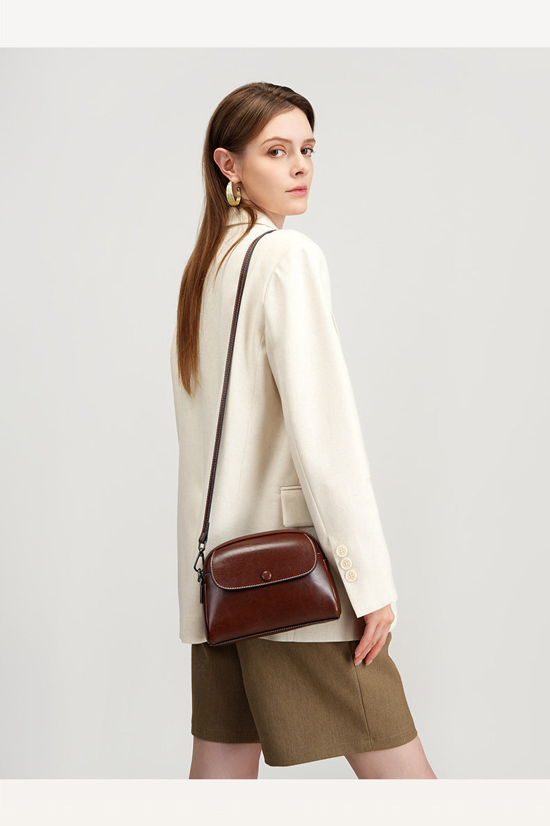 Model with brown mini crossbody bag worn crossbody style
