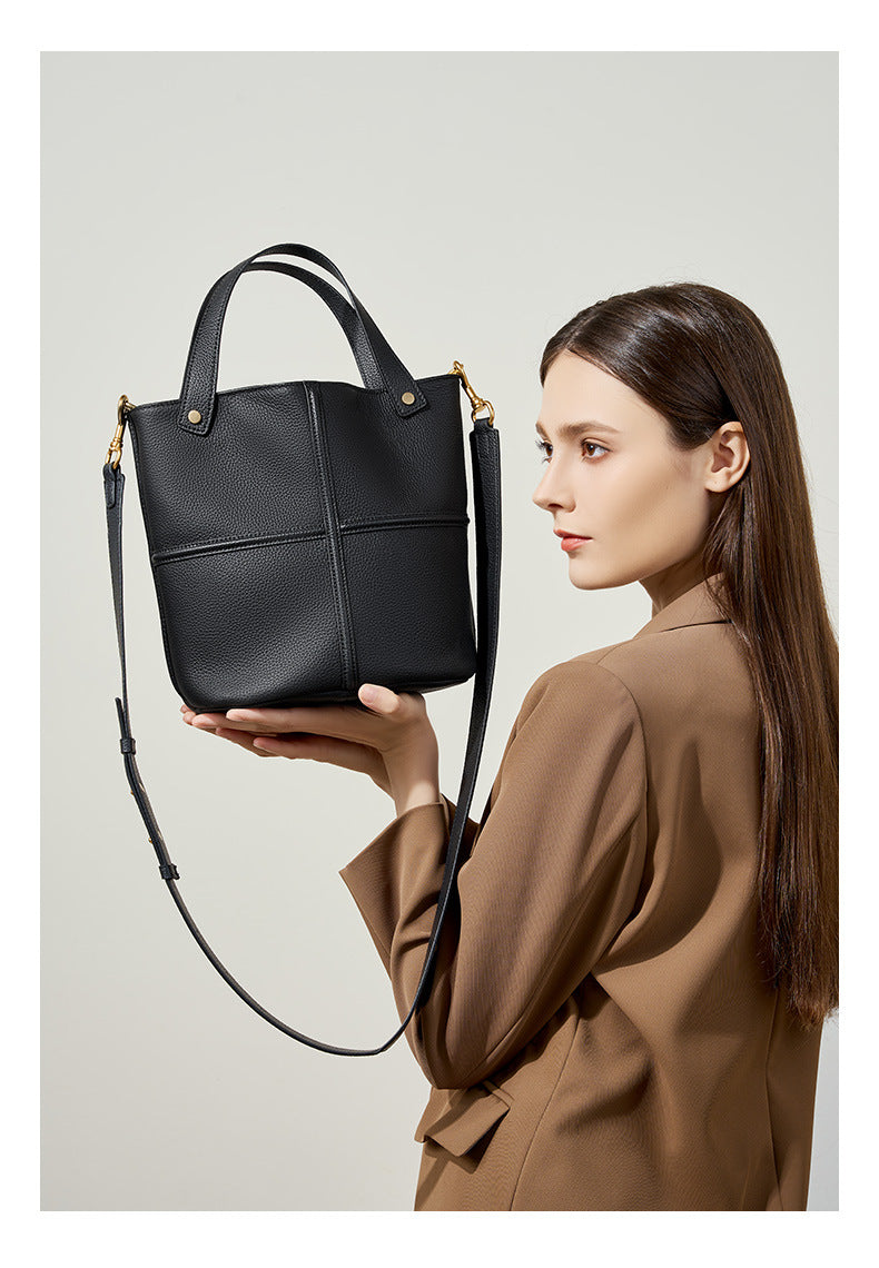 Model holding black bucket bag showing its front design