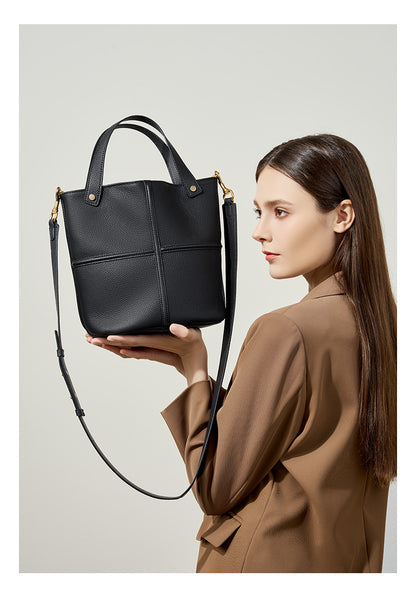 Model holding black bucket bag showing its front design